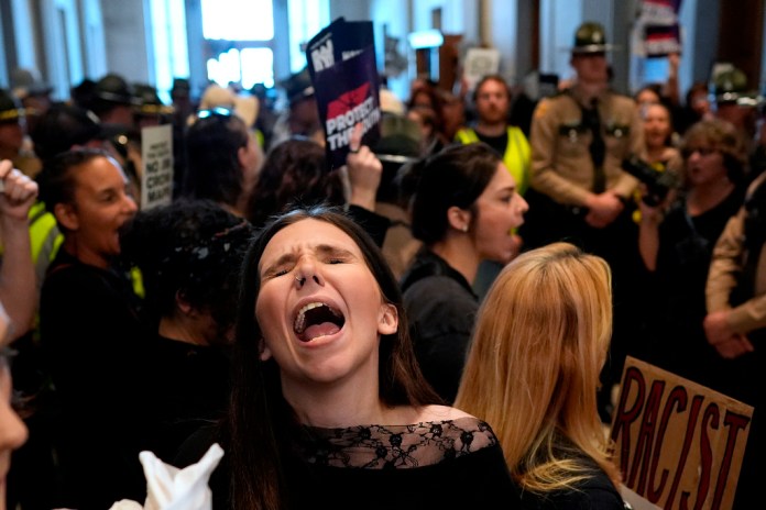 A woman protests outside the House chamber before a special session of the state legislature to redraw U.S. Congressional voting maps Thursday, May 7, 2026, in Nashville, Tenn.