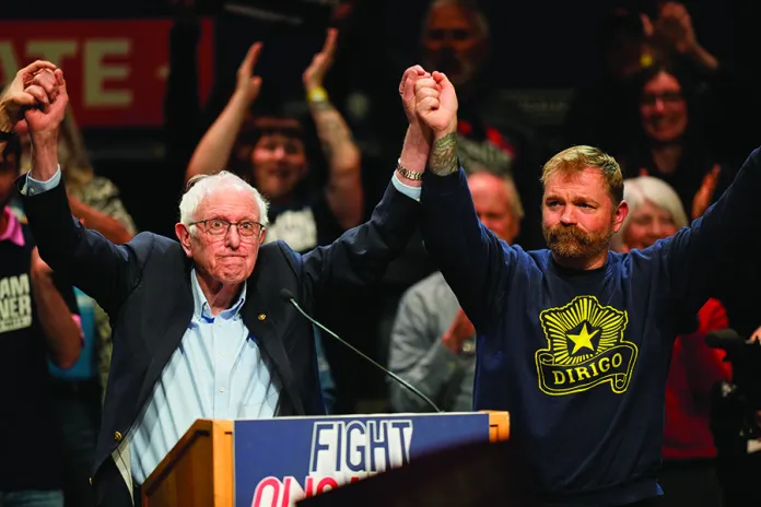 Graham Platner, Democratic candidate for U.S. Senate, and Sen. Bernie Sanders, left, join hands at an event in Orono, Maine, Sunday, May 24, 2026. (AP Photo/Robert F. Bukaty)