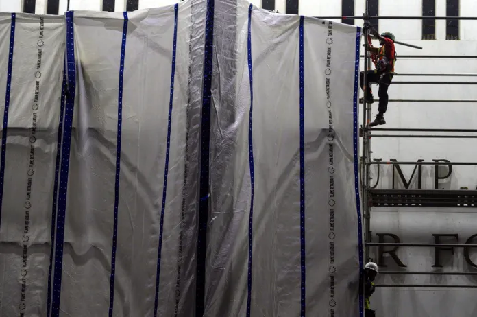 Workers install tarps on the scaffolding at the John F. Kennedy Center for the Performing Arts in Washington, Saturday, June 13, 2026.