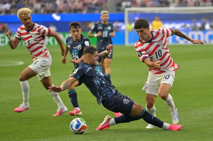 United States' Christian Pulisic (10) is challenged by Paraguay's Juan Jose Caceres (4) during the World Cup Group D soccer match between the United States and Paraguay in Inglewood, Calif., near Los Angeles, Friday, June 12, 2026.