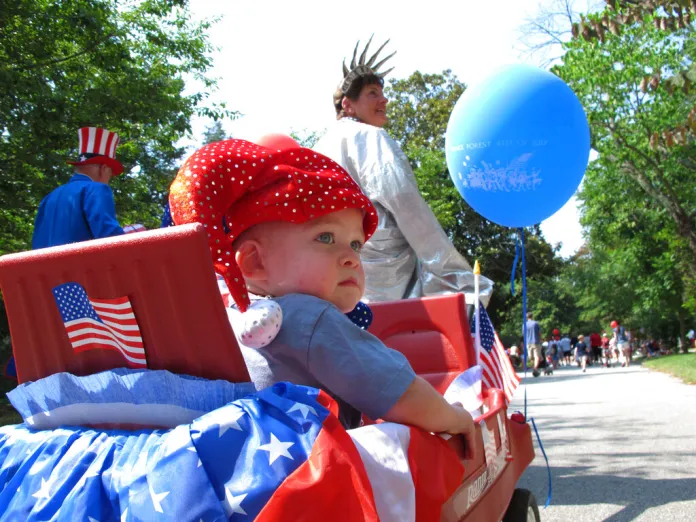 "Lady Liberty" Bonnie Johnson, 70, tows grandson Turner Johnson, foreground,16 months, in the annual Children's Parade on Monday, July 4, 2011, in Wake Forest, N.C. Johnson has been portraying Lady Liberty for 27 years, and this is Turner's first parade. (AP Photo/Allen Breed)